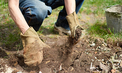 Man removing soil waste from the ground